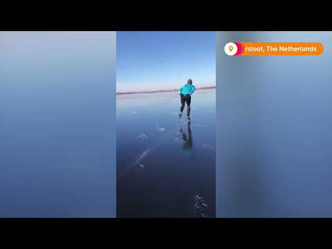 滑冰者滑過荷蘭的湖泊 (Skaters slide across a lake in the Netherlands)