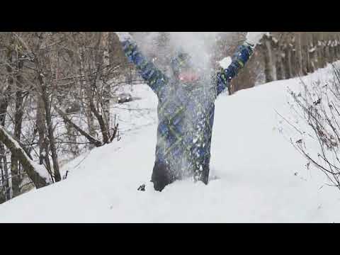 Snowfall in winter. The girl rejoices in the white fluffy snow and sprinkles herself with snow.