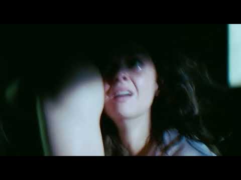 Trailer still: stark hallway and buzzing lights hinting at paranoia