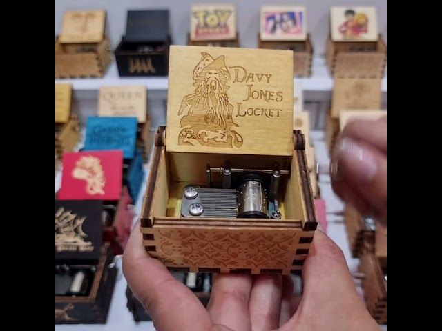 Vídeo relacionado con Caja de música de Los Piratas del Caribe con manivela de madera tallada, regalo musical, reproduce el tema de Davy Jones, negro