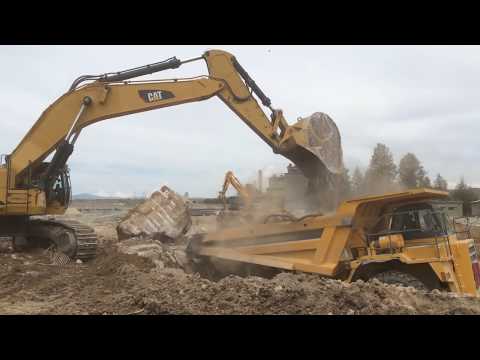 Caterpillar 385C Excavator Loading Concrete Blocks On Komatsu Dumpers