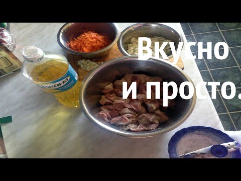 Куриные желудки тушенные на сковородке с луком и морковью.