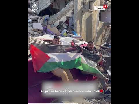 شابان يرفعان علم فلسطين على ركام منزلهما المدمر في غزة
