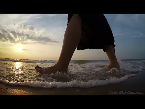 Barefoot legs of young female walking on the sunset beach, Biruchiy island,Ukraine