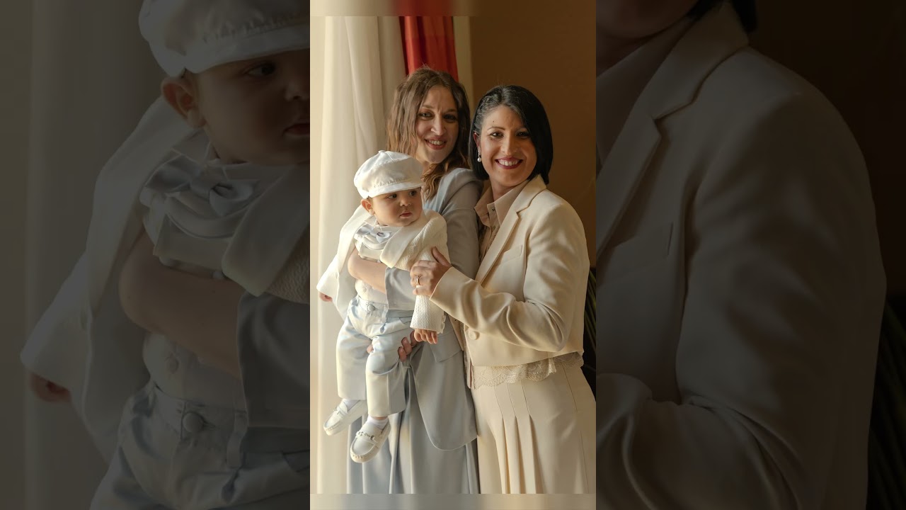 Due donne e un bambino in abiti eleganti ridono insieme durante il backstage di un battesimo a Orta San Giulio, fotografo Novara.