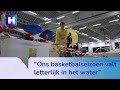 Basketballers spelen met poncho's en paraplu's onder lekkend dak