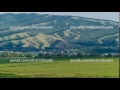Beautiful Landscape Of A Field With Hay Bales Against The Big Hill