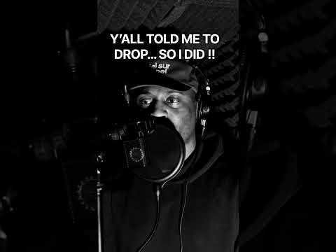 JEFFERY in a hood and cap performing into a microphone in the official ALBANIE promotional clip