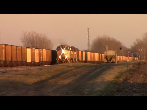 Two UP coal trains meet west of Nevada, Iowa at sunset