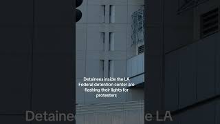 Detainees inside the Federal building are seen flashing a light at protesters outside.