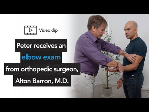 Peter receives an elbow exam from orthopedic surgeon, Alton Barron, M.D.