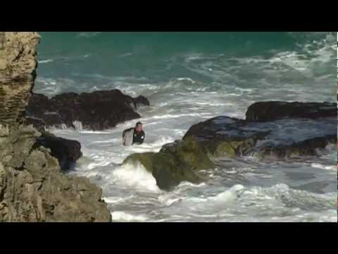 Surfer getting smashed on rocks