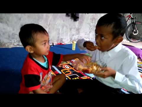 Adik-kakak makan sepiring berdua