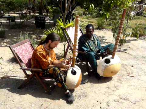 Jali Sherrifo Konteh plays Kora with a student at Gunjur Project Lodge, The Gambia