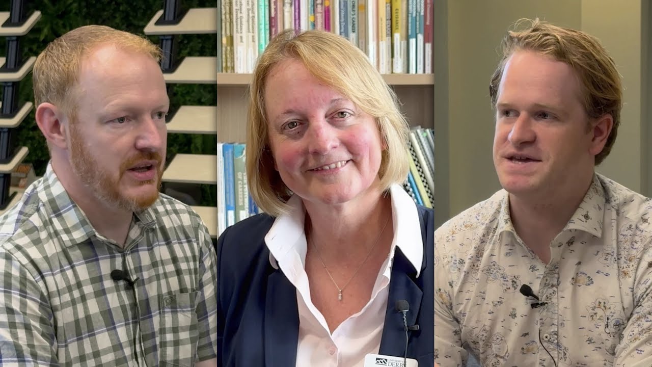 Dr Alison Hardman has a blonde bob haircut and wears a white shirt underneath a blue suit jacket. She is sitting in front of a bookcase filled with academic textbooks.