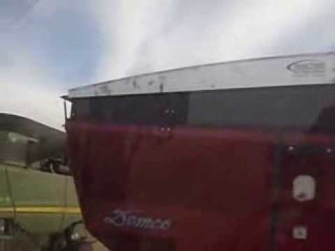 combine dumping into grain cart on the go