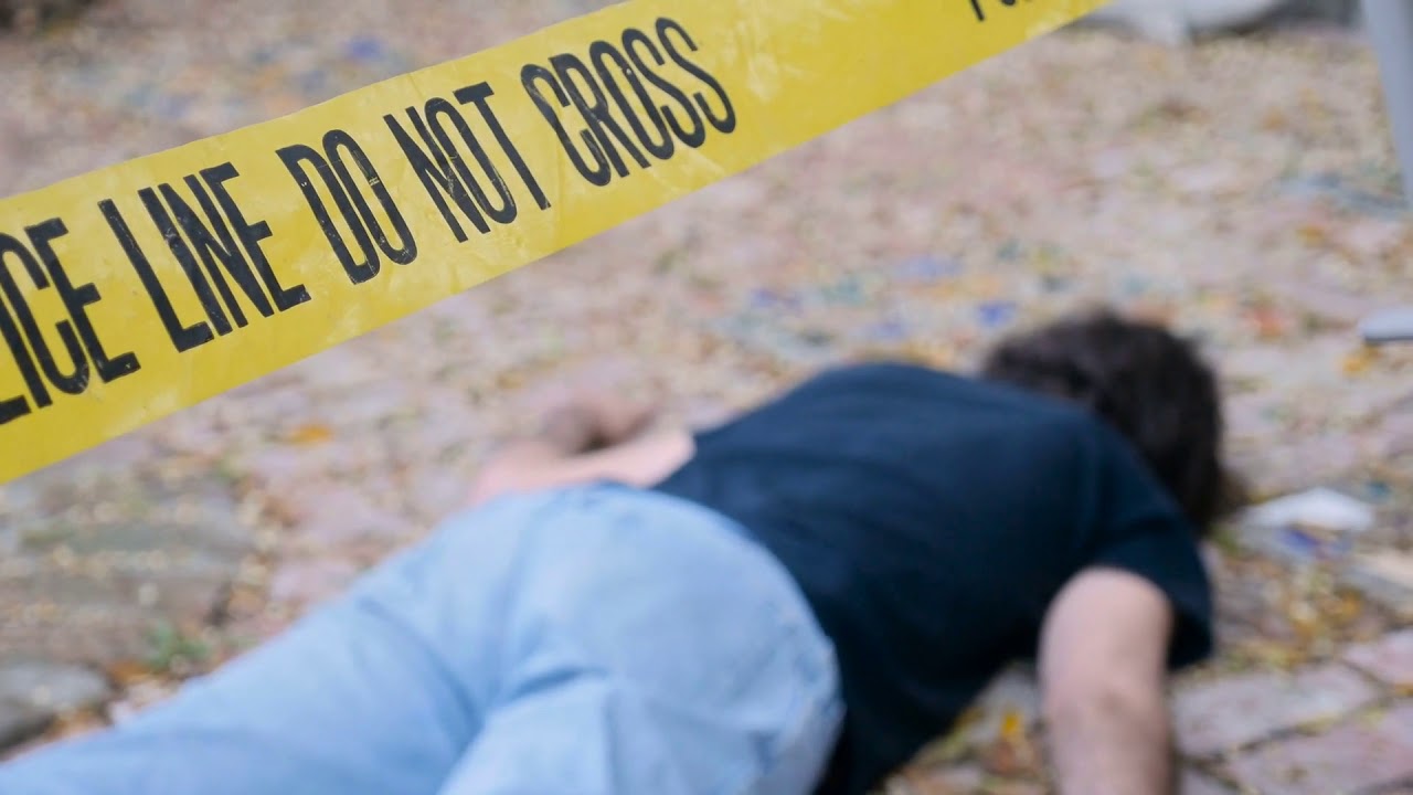 a dead murdered killed body roped off with police line do not cross tape at crim cene