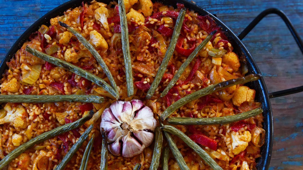 a pan of Spanish oven-baked rice topped with garlic and green beans