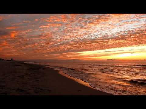 Gorgeous sea at sunset with waves breaking on the beach