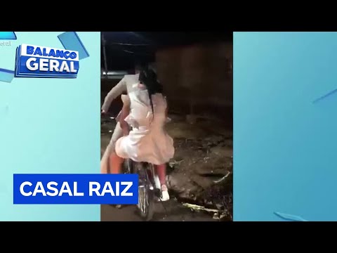 Noivos recém-casados saem da cerimônia andando juntos na mesma bicicleta