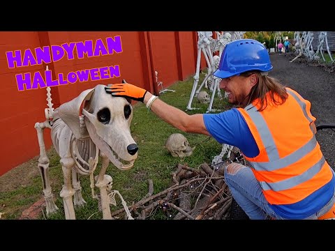Man in an orange safety vest and blue helmet pets a life-size skeleton horse in a Halloween display by a red wall.