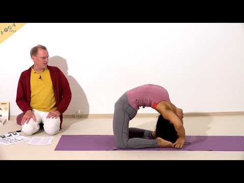 Erhobener schlafender Diamant mit Händen am Fuß Supta Vajrasana - Yoga Asana Lexikon