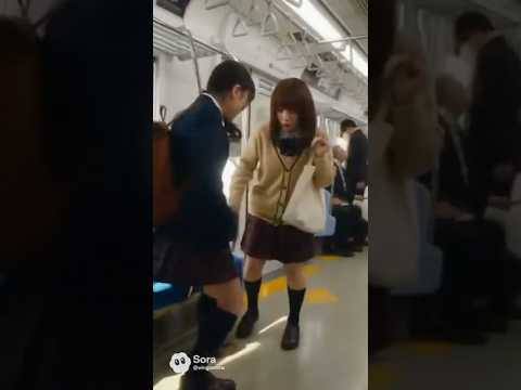 二人の女子高校生が電車の中で一つの空いた座席を取り合っている