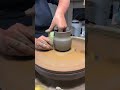 Throwing a curvy mug of the potters wheel with a profile rib I made.