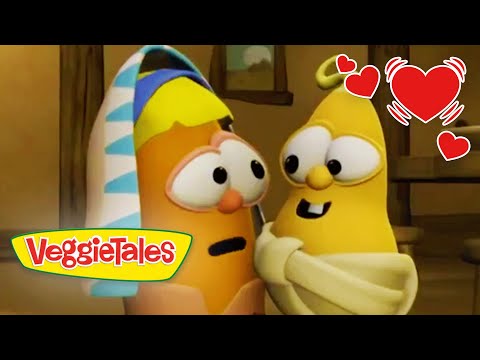 Two VeggieTales characters share a hug, smiling as red hearts surround them, logo at bottom left.