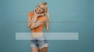 Smiling happy beautiful blonde woman in orange T-shirt and shorts having fun: running, turning back