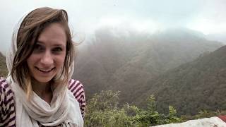 Rachael Daws wears a head scarf and stands in front of the Himalayan mountains on an overcast day.