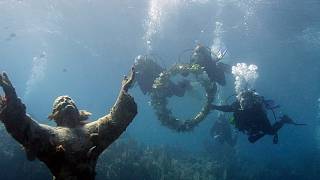 Taucher säubern Italiens Unterwasserstatue Christus der Tiefe