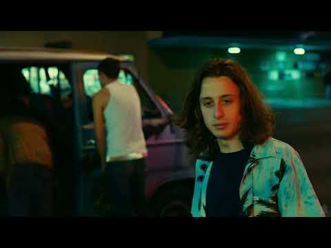 Electrick Children trailer still: Rachel holds a blue cassette as city lights blur behind her