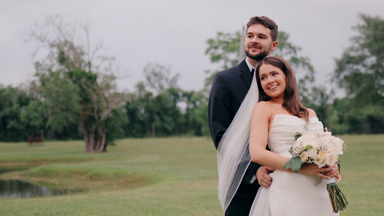 Couple standing together by the water at golden hour