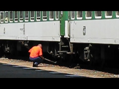 Czech Republic: Praha-Smichov, a railway wheel tapper checks train wheels in the station sidings