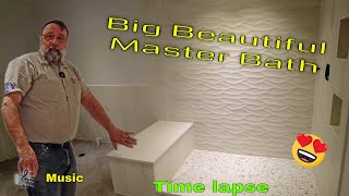 Master bathroom with  combination of huge wavy and flat tiles, heated herringbone tile floor. Music