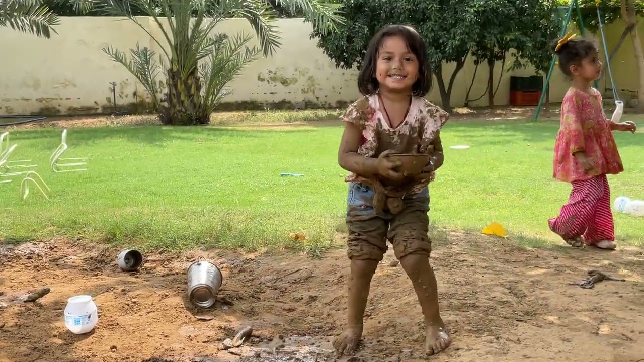 Children exploring earth and water on the campus grounds