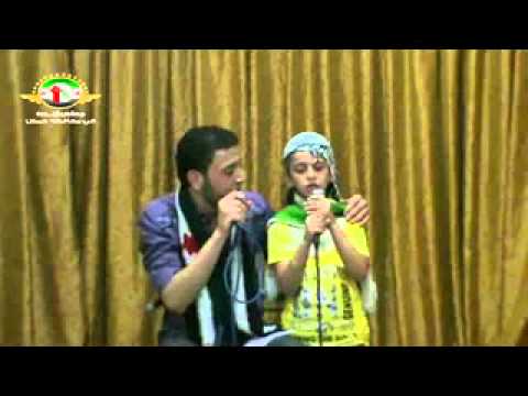 المنشد محمد أبو يحيى وطفلة صغيرة يغنيان "حانن للحرية حانن" أثناء جلسة ثورية في حي الخالدية في مدينة حمص