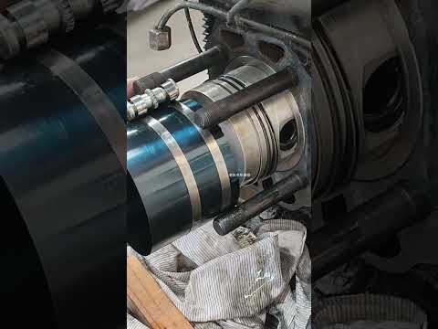 Piston ring compressor tool being used during engine repair