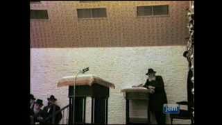 הדלקת נרות חנוכה ושירת "הנרות הללו" אצל הרבי - התמונה מוצגת ישירות מתוך אתר האינטרנט יוטיוב. זכויות היוצרים בתמונה שייכות ליוצרה. קישור קרדיט למקור התוכן נמצא בתוך דף הסרטון