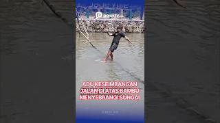 LOMBA ADU KESEIMBANGAN JALAN DI ATAS BAMBU MENYEBRANGI SUNGAI