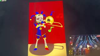 Pomni playing trombone on stage