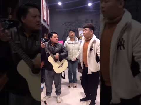 Chinese pinching finger with hammer and playing guitar. Hammering wall