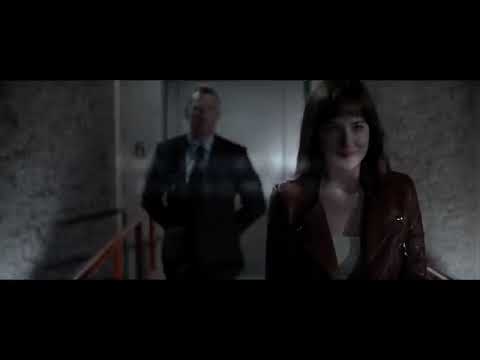 Official trailer still of Fifty Shades of Grey with Christian and Ana in a high-contrast city interior