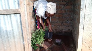 African village life cleaning pit latrine using La