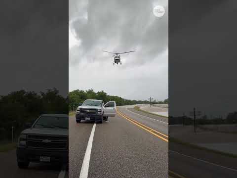 Dramatic POV shows man surrounded by floodwaters on Texas highway