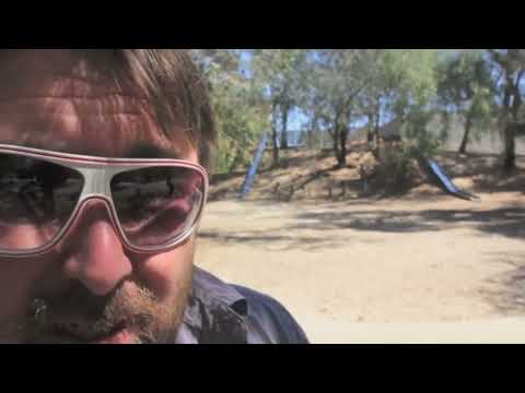 Adam the Woo rides a bike down a slide