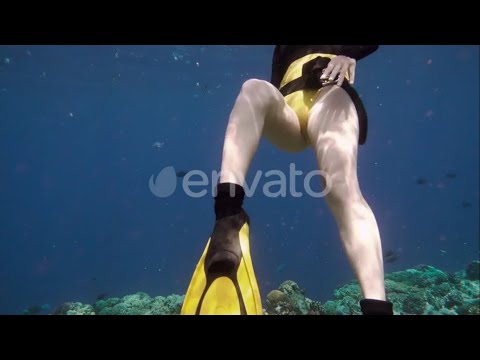 Sexy Girl in yellow bikini wearing yellow fins - Maldivian diving with rays of Sun