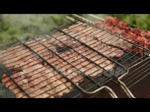 Chunks of meat fried metal grid outdoors