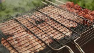 Chunks of meat fried metal grid outdoors